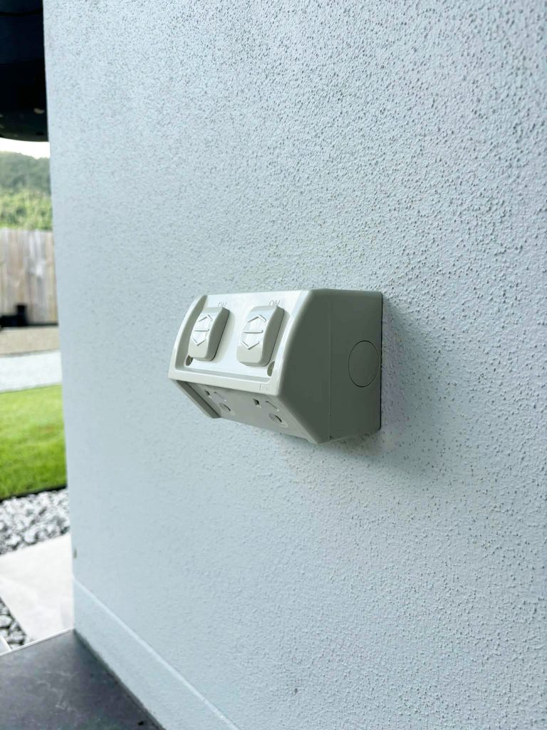 Weatherproof power point mounted on an exterior wall